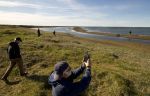 Along the Chukchi Sea near Wainright, Alaska, scientists working for Shell fanned out in summer 2011 in preparation for the company's offshore drilling, which began this weekend. One archaeologist uses a GPS device to record the precise location of a Native American sod house on the shore.